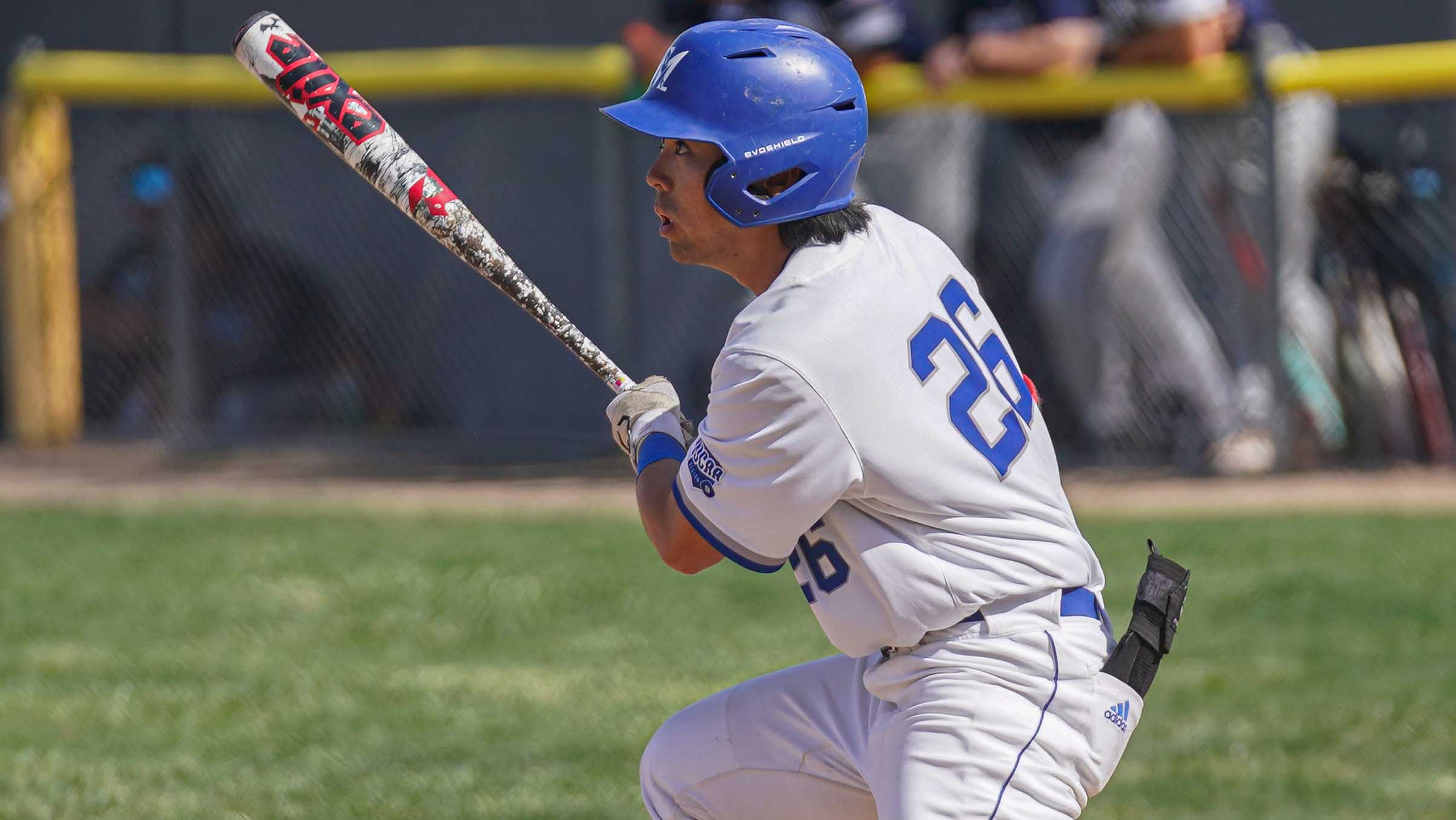 College baseball player hitting the ball.