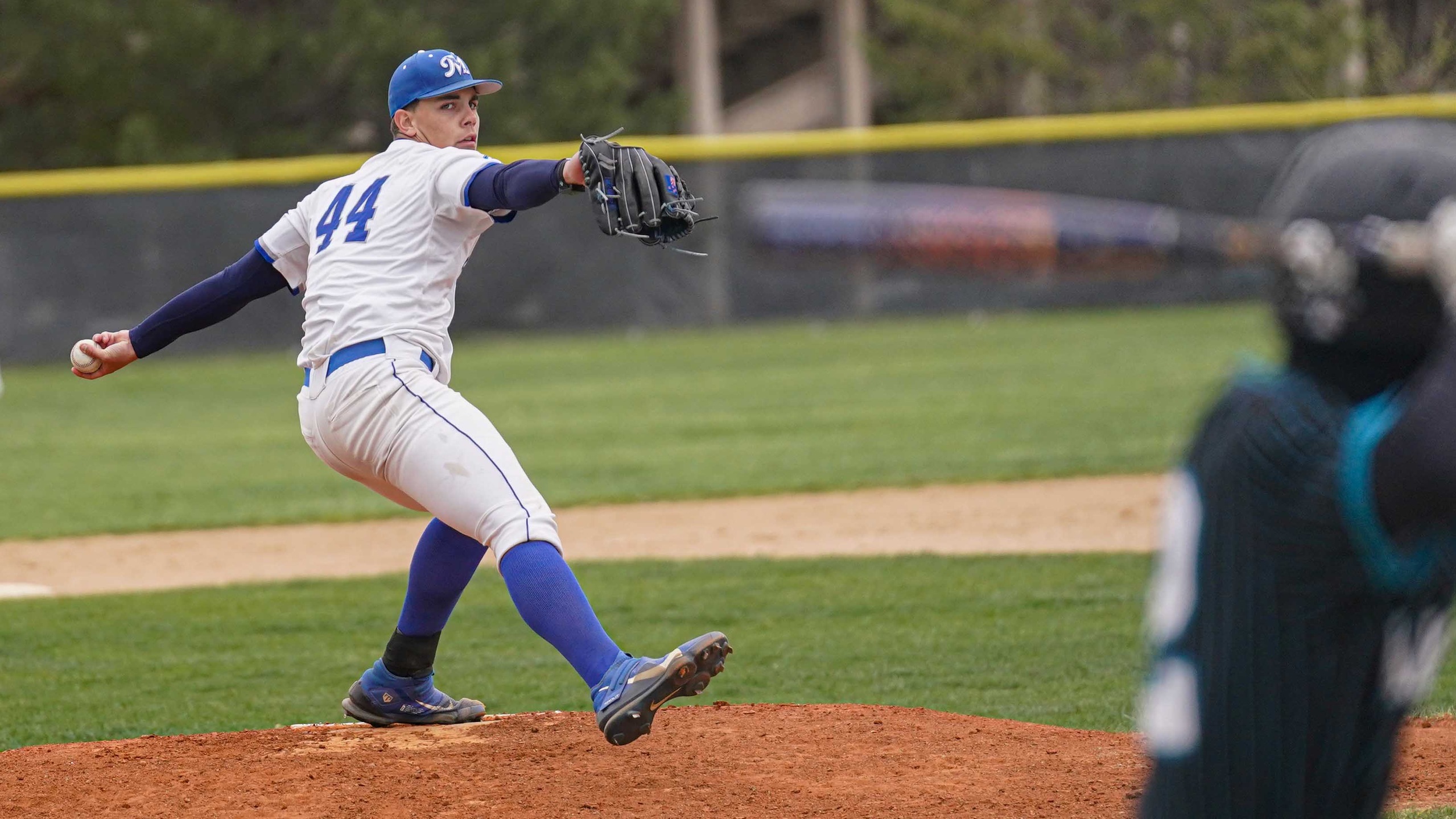 College baseball pitcher throwing to batter.