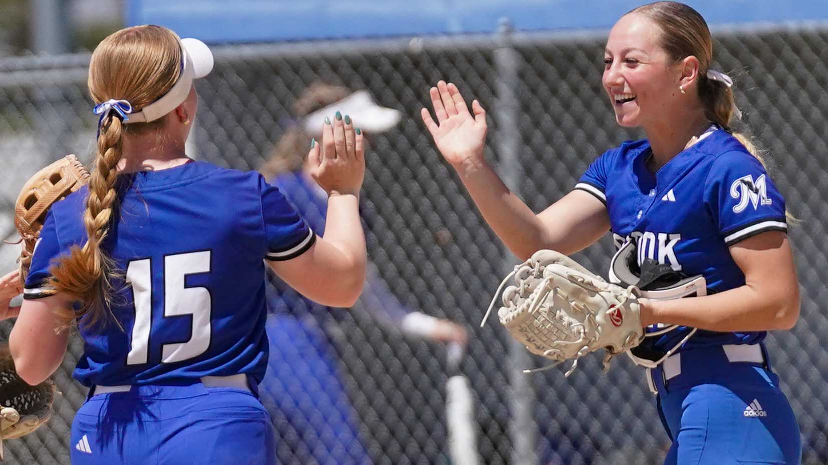 College softball players celebrate a great play.