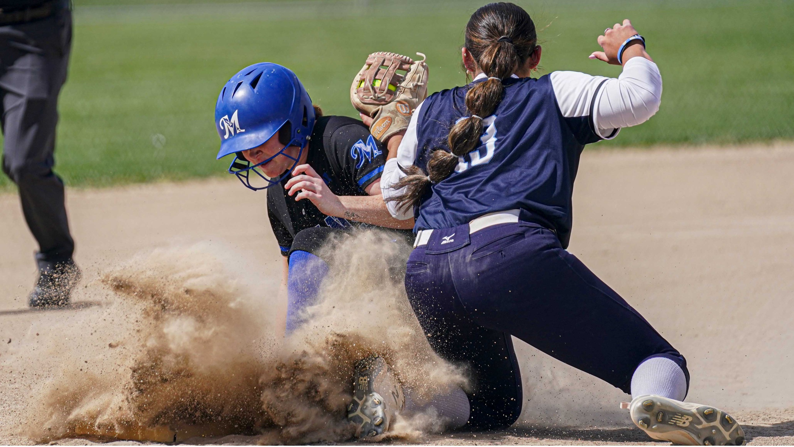 Softball player slides into second base