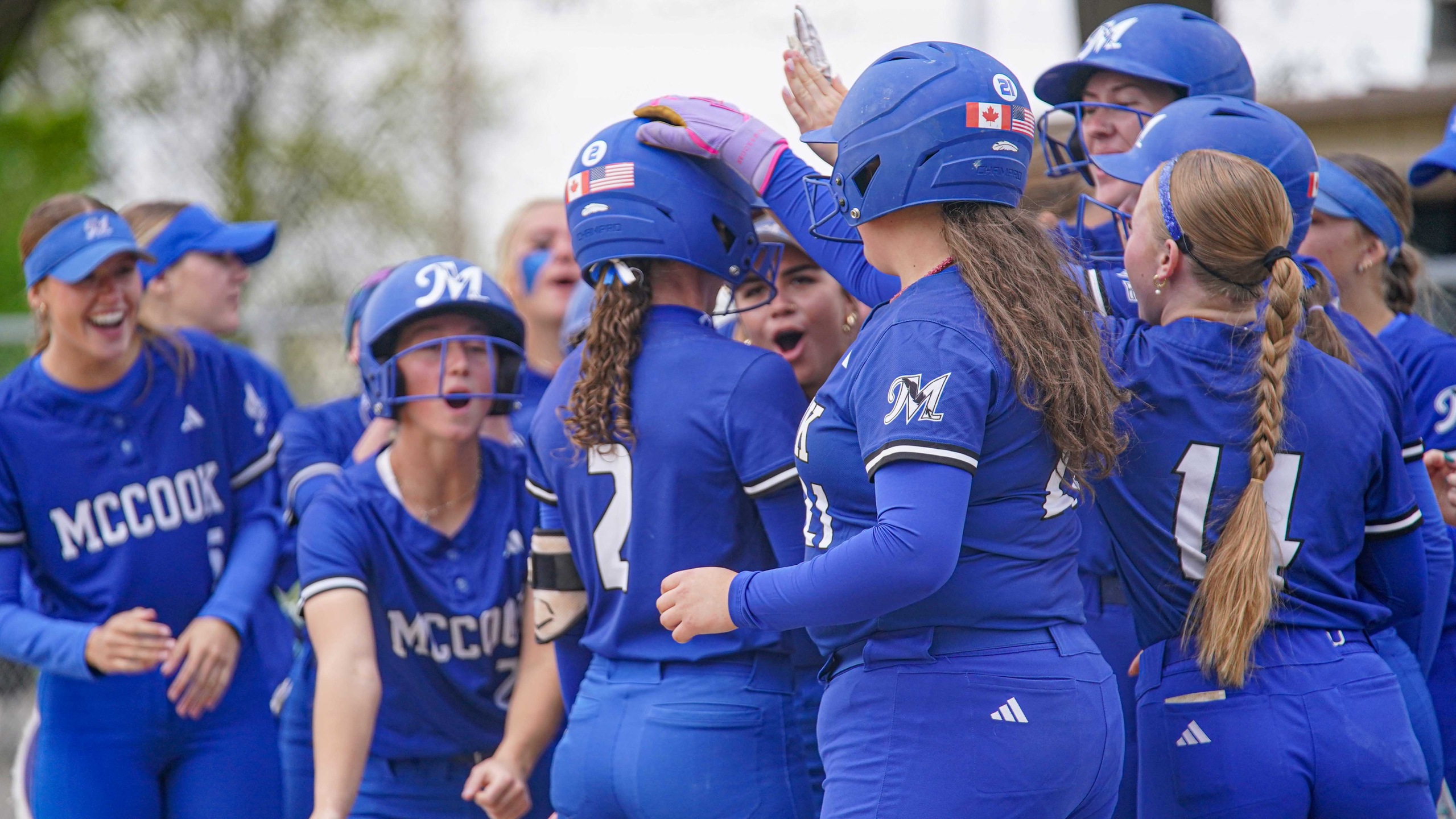 College softball players celebrate home run.
