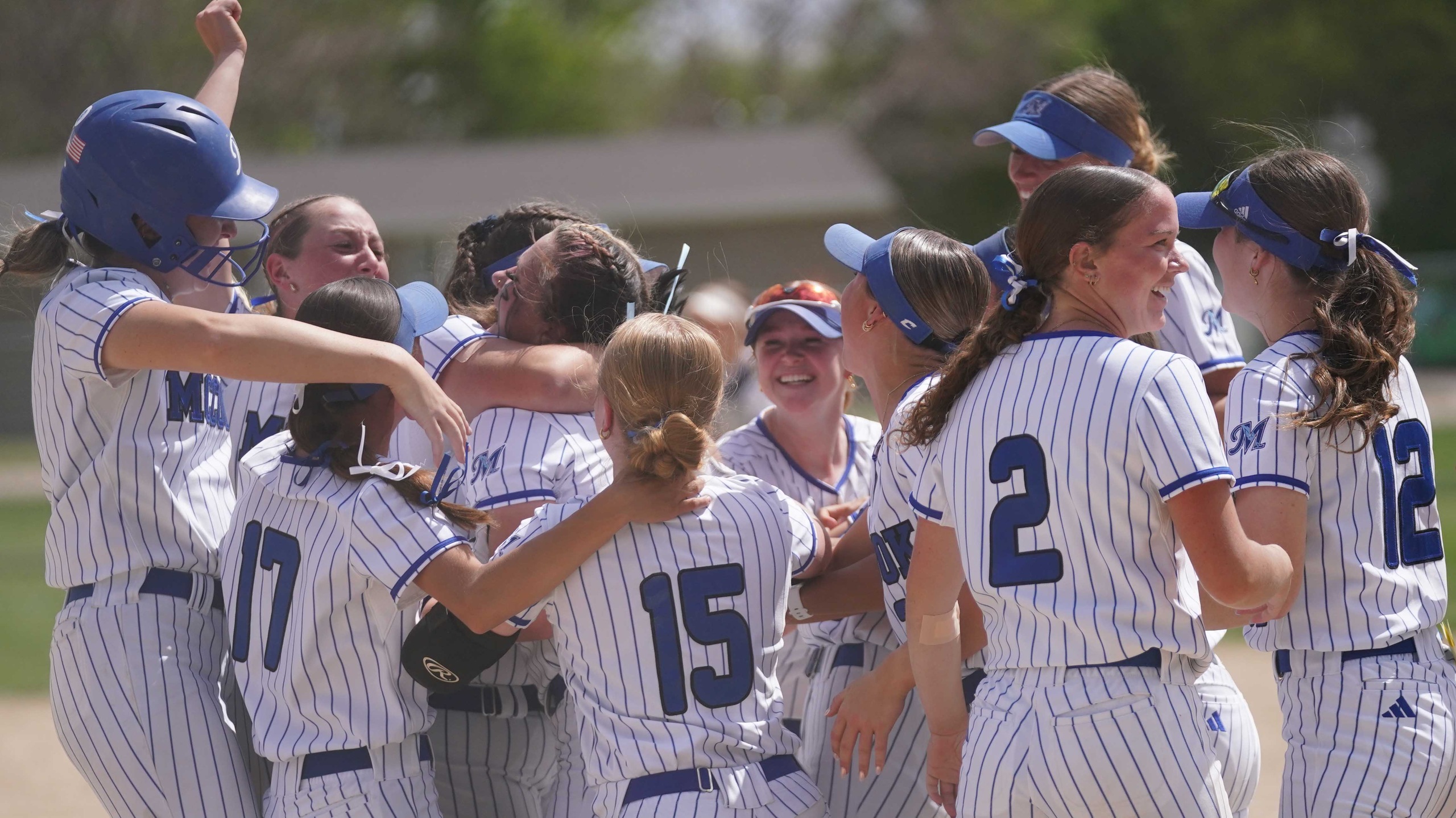 College softball players celebrate win.