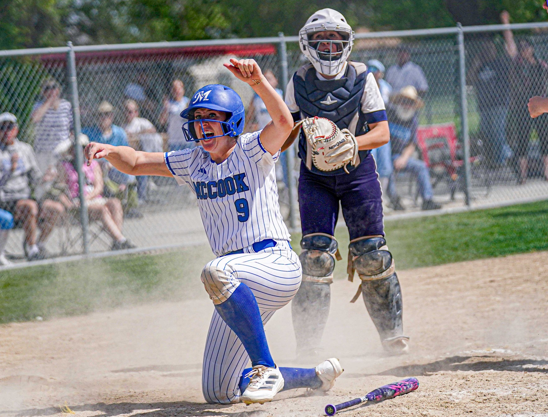 College softball player celebrates scoring winning run.