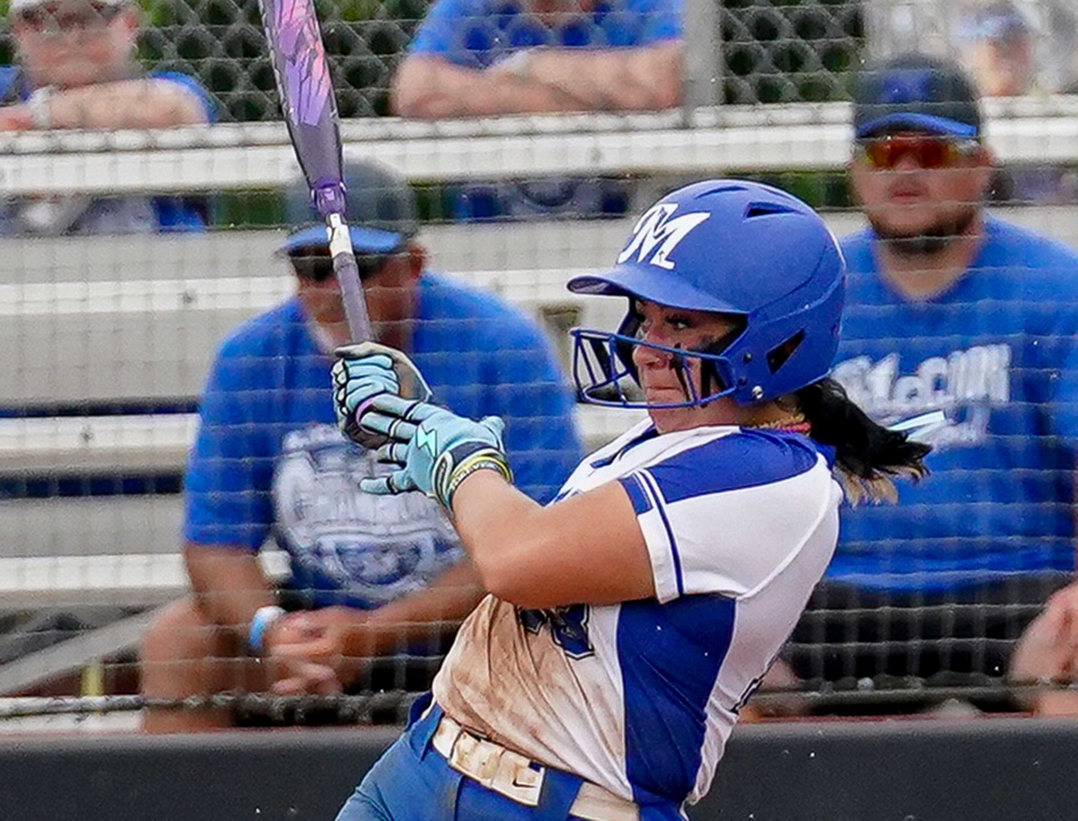 College softball player hits the ball.