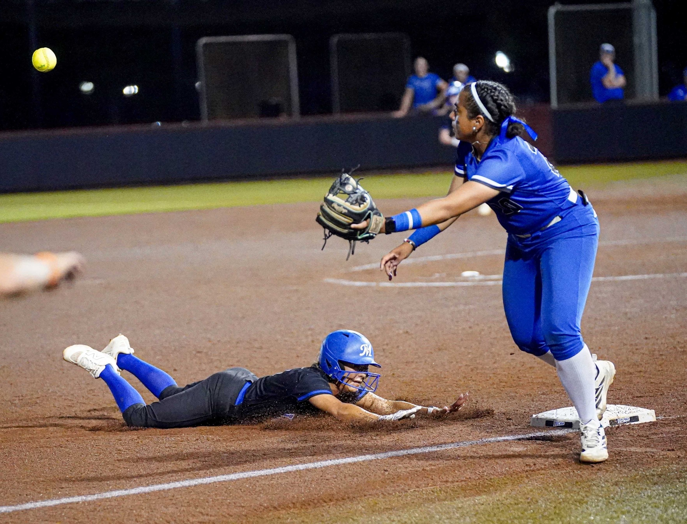 College softball player slides into third base.