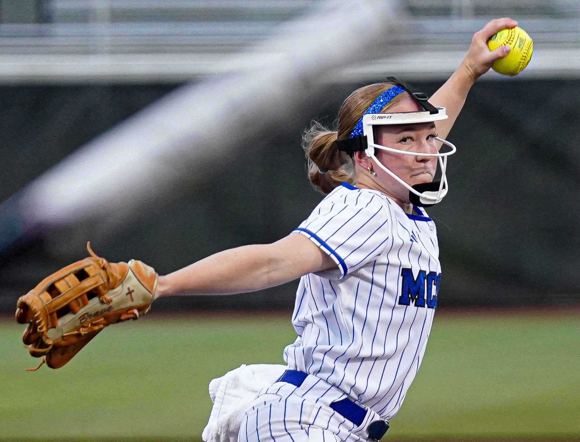 College softball player pitching the ball.