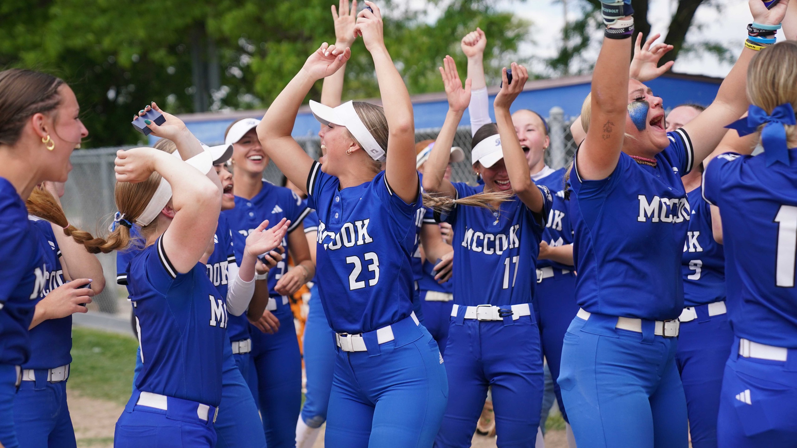 College softball players celebrate winning a tournament.